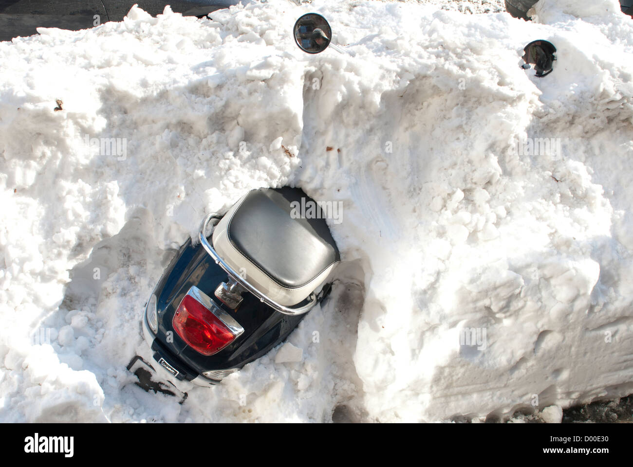 Moped buried in snow on the side of the road Stock Photo