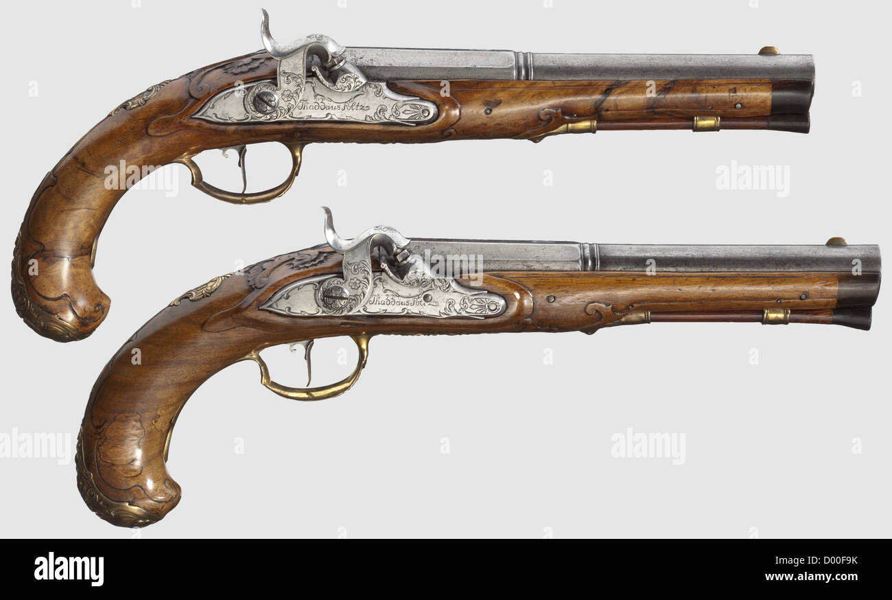 A cased pair of Czech percussion pistols,Thaddäus Poltz,Karlovy Vary,circa 1770.Octagonal two-stage barrels in 14 mm calibre,round and smooth after a girdle,with surface-mounted brass front sights.At the breeches remnants of gilt floral engravings as well as the numbers "1" and "2".Florally cut,converted percussion locks,each signed "Thaddeius Poltz".Carved,bright walnut stocks with horn noses and bronze fittings with rocailles in relief.Wooden ramrods with horn tips.Length 33.5 cm each.In a later(?)wooden case complete with extensive accessorie,Additional-Rights-Clearences-Not Available Stock Photo