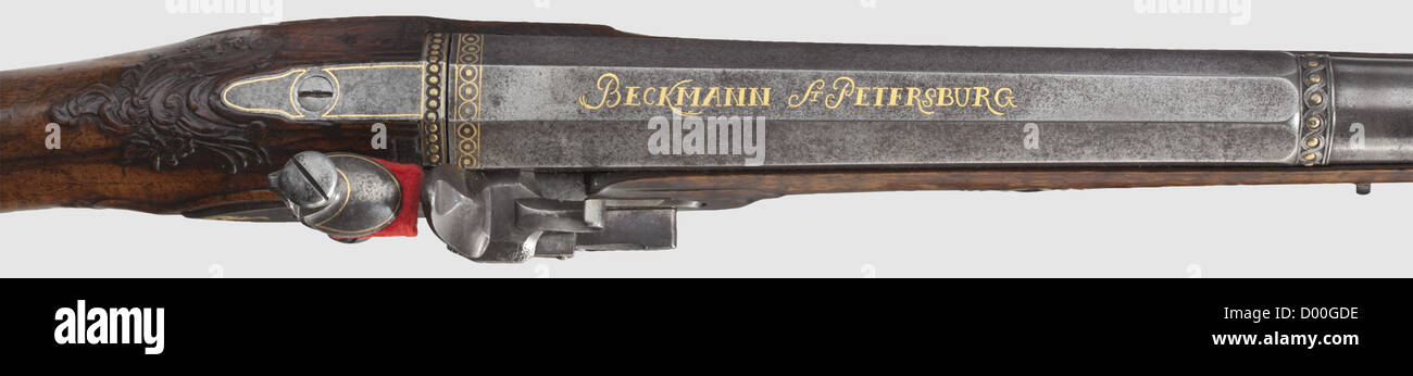 A flintlock shotgun,Russian.Beckmann,St.Petersburg,circa 1800.Two-stage barrel,octagonal then round after a cut and gilt girdle,with smooth bore in 20.5 mm calibre and patent breechblock.Silver-mounted muzzle and silver front sight,over the breech the gold-inlaid signature 'BECKMANN ST PETERSBURG'.Gold-bushed vent hole as well as gold-inlaid breech plug.Cut flintlock with floral gold inlays and gold-lined pan as well as frizzen on rollers,the lockplate with repeated signature.Beautiful,florally carved walnut full stock with patchbox and horn nose,Additional-Rights-Clearences-Not Available Stock Photo