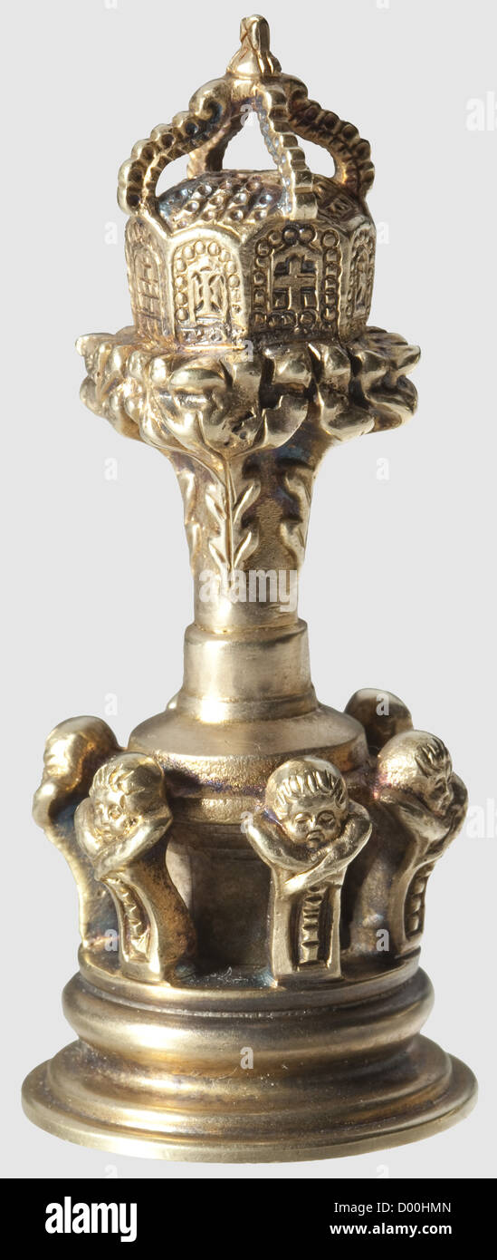Kaiser Wilhelm II - A personal seal from Achilleion Castle,on Corfu.Silver,gold-plated,the handle consisting of an Imperial crown on an oak leaf embellished pedestal,the seal's base surrounded by a frieze of putto heads.The seal matrix cut with the monogram 'WII IR' beneath an Imperial crown and set between 'Achilleion' and 'Corfu'.Height 70 mm,weight 122 g.Also two envelopes with gold/blind embossing 'Achilleion,Corfu' under an Imperial crown,one envelope with a golden imprint made by the seal at hand and addressed to 'Reichs Kanzler FÜrsten von BÜl,Additional-Rights-Clearences-Not Available Stock Photo