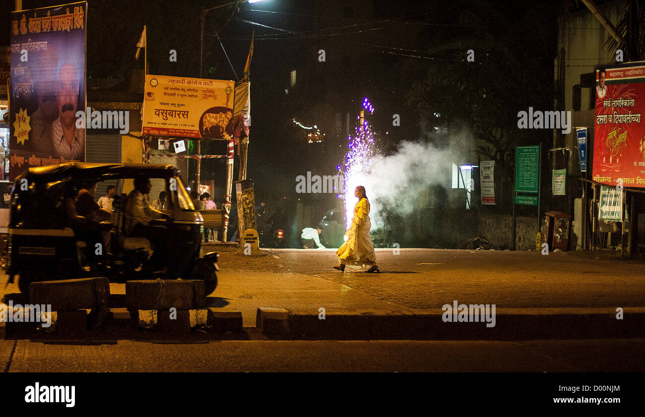As people all over India celebrate Diwali, the festival of light, a woman walks past street celebrations in the western city of Pune, Maharashtra Stock Photo