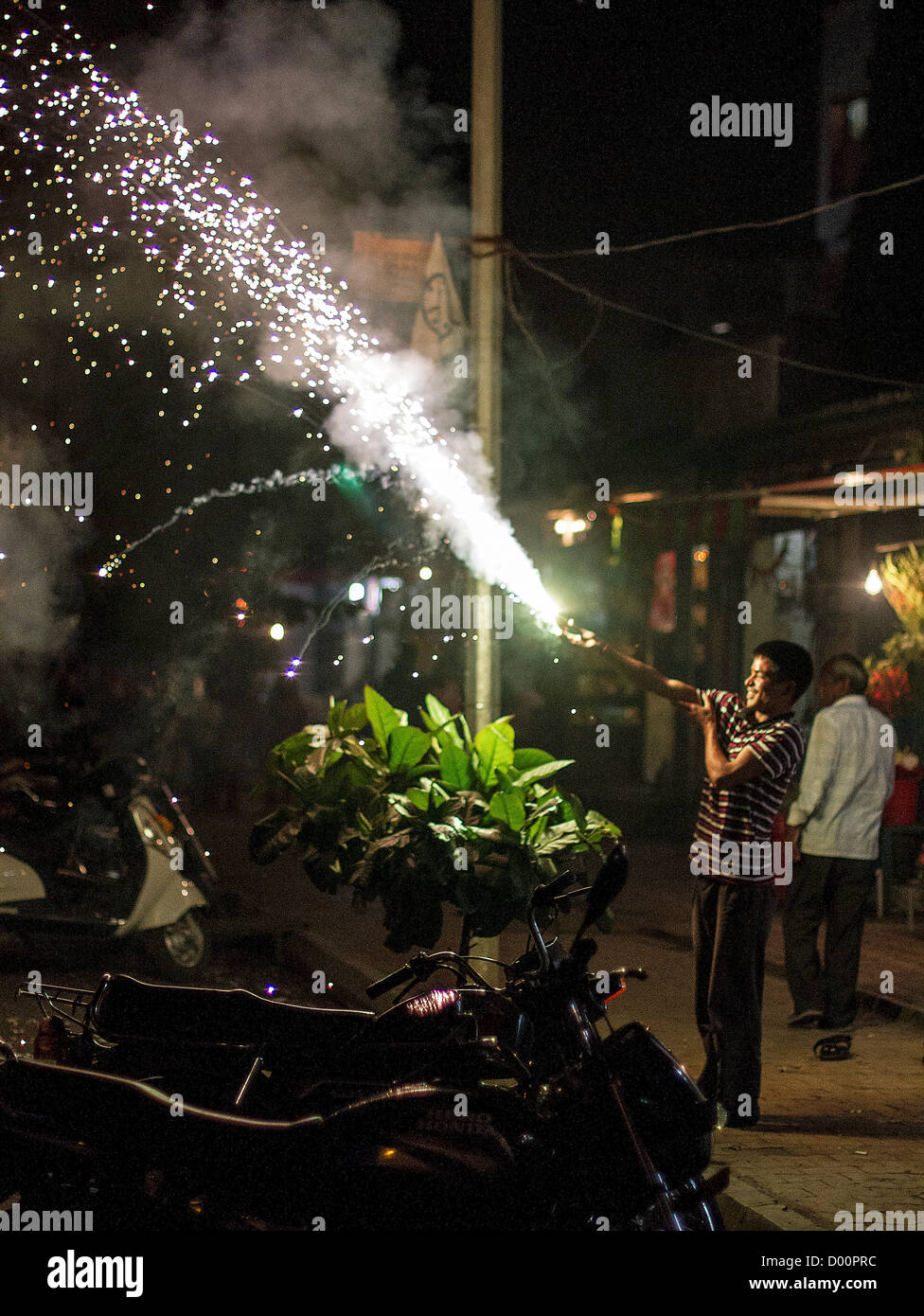 India celebrates Diwali, the festival of light. People all over India set off firecrackers and fireworks in celebration. Here a man sets light to a 'Phooljhari' roughly translated as 'flower stick'. Stock Photo