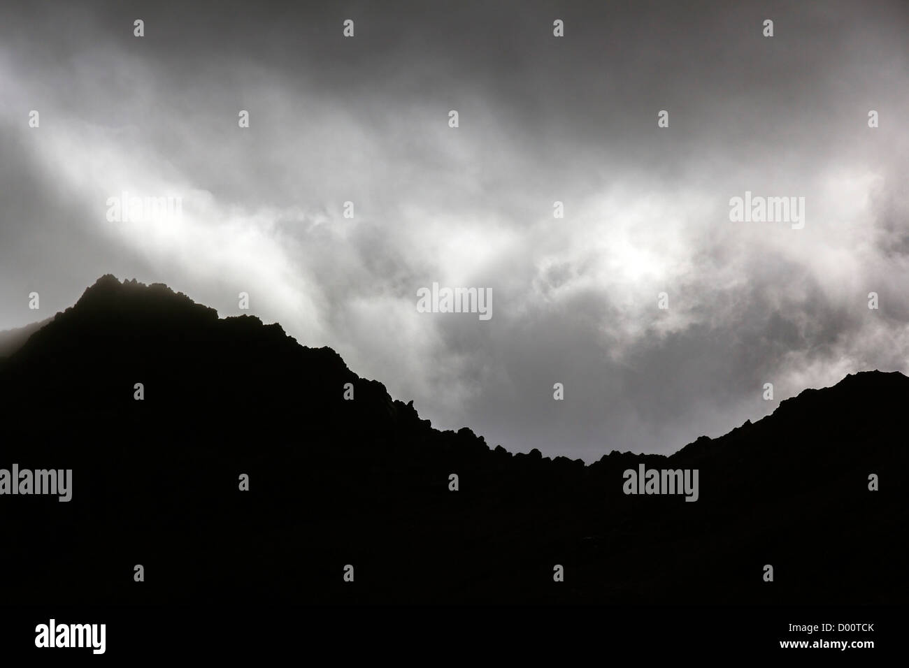 Dramatic grey cloudy misty skies over silhouette of Black Cuillin Mountain ridge, Sligachan, Isle of Skye, Scotland, UK Stock Photo