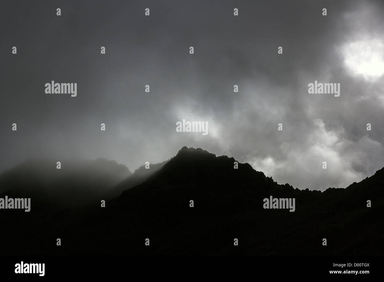 Dramatic grey cloudy misty skies over silhouette of Black Cuillin Mountain ridge, Sligachan, Isle of Skye, Scotland, UK Stock Photo
