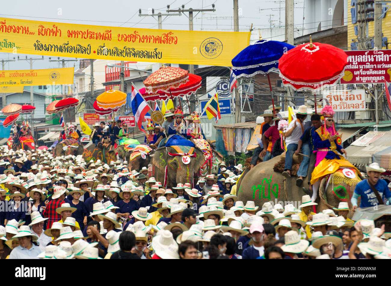 Initiates dressed in garish costumes and sunglasses in procession on elephants from Wat Hat Siao, Elephant Back Ordination Ceremony (Buat Chang), Si Sachanalai, Sukhothai, Thailand Stock Photo