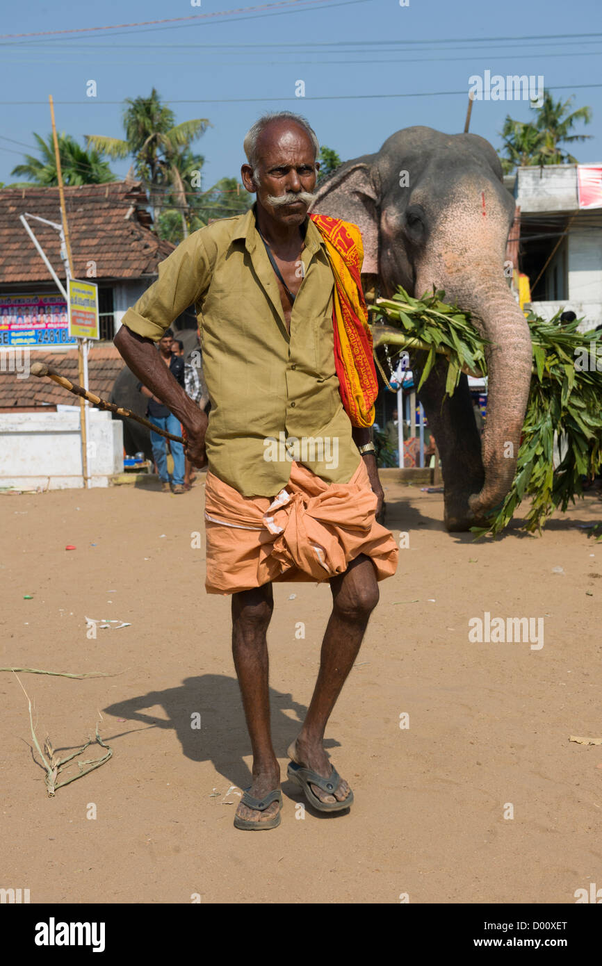 Mahout walking in front of his elephant at the Goureeswara Temple Festival, Cherai, near Kochi (Cochin), Kerala, India Stock Photo
