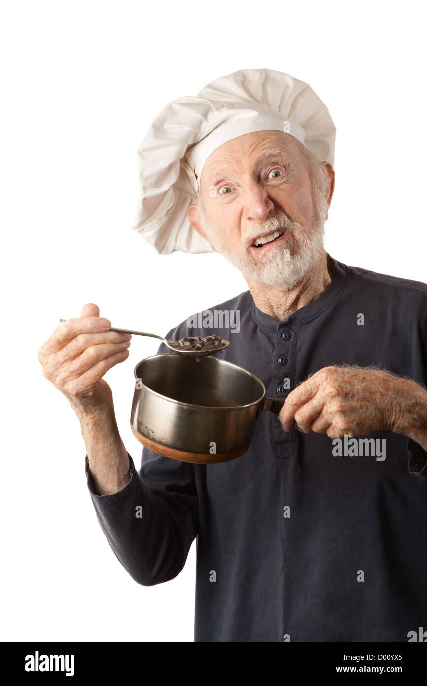 Funny senior chef with big white hat and pot of beans Stock Photo