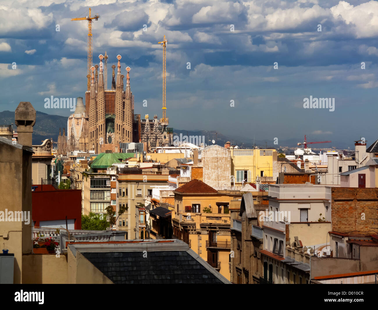 View over the rooftops of Barcelona towards the unfinished Templo Expiatioro de la Sagrada Familia designed by Antoni Gaudi Stock Photo