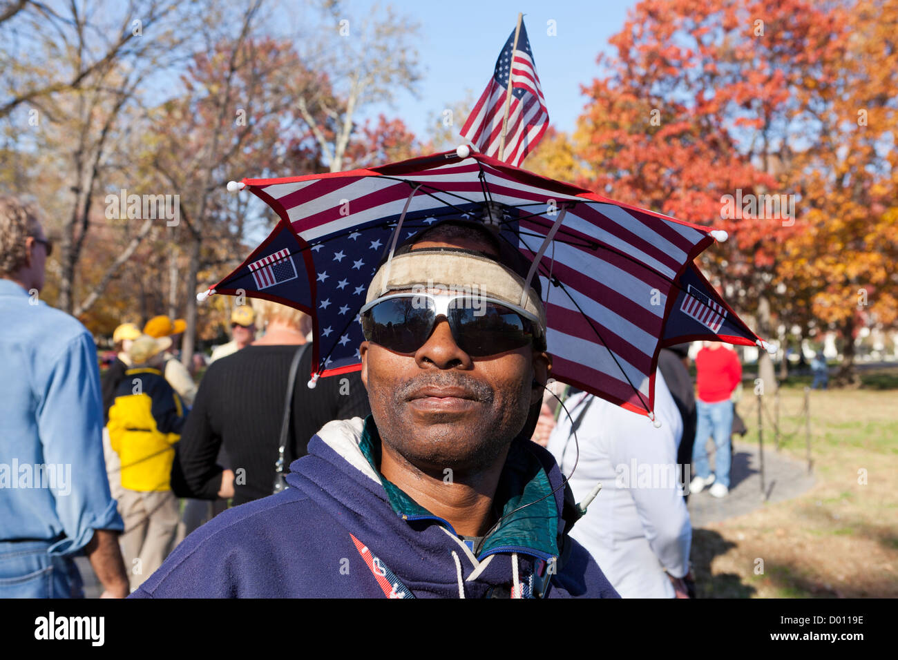 Man wearing American flag umbrella hat Stock Photo