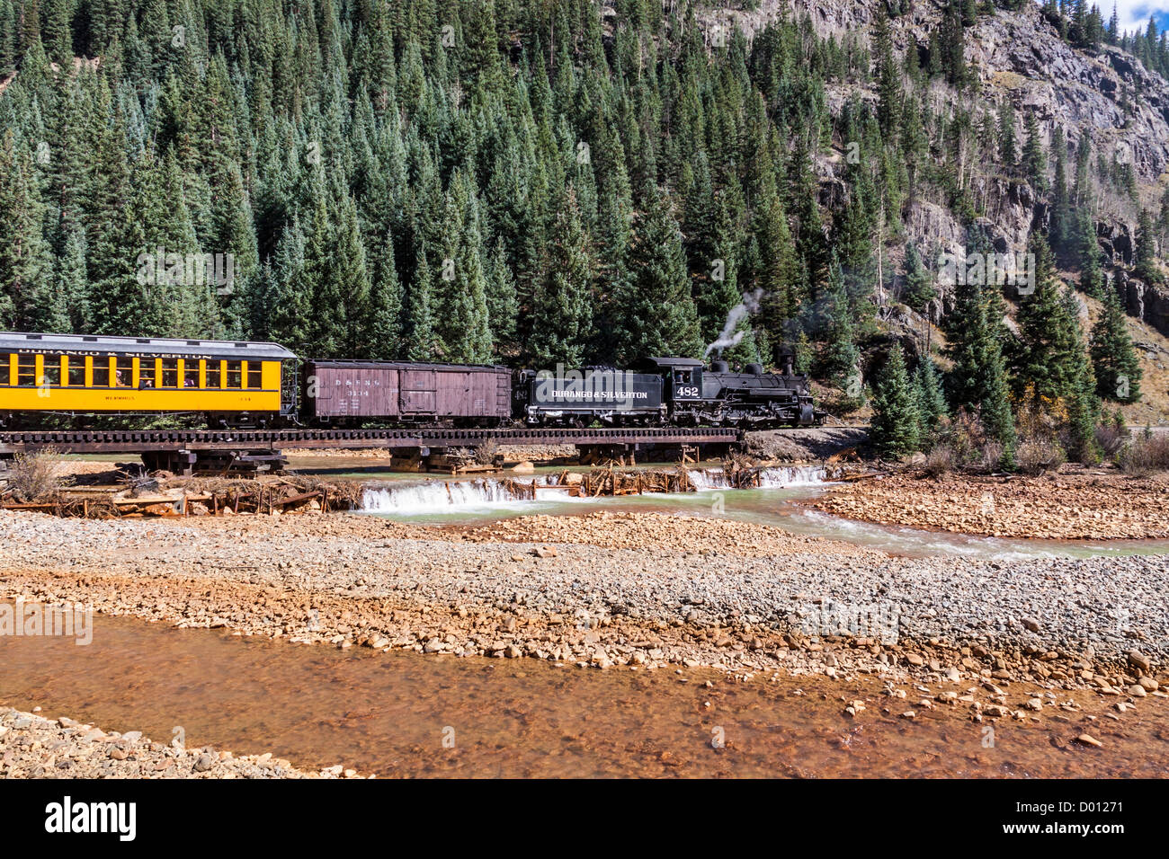 1925 Baldwin Steam Locomotive, 2-8-2 configuration, Mikado type, with antique, classic railcars, at the Animas River Bridge near Silverton, Colorado. Stock Photo
