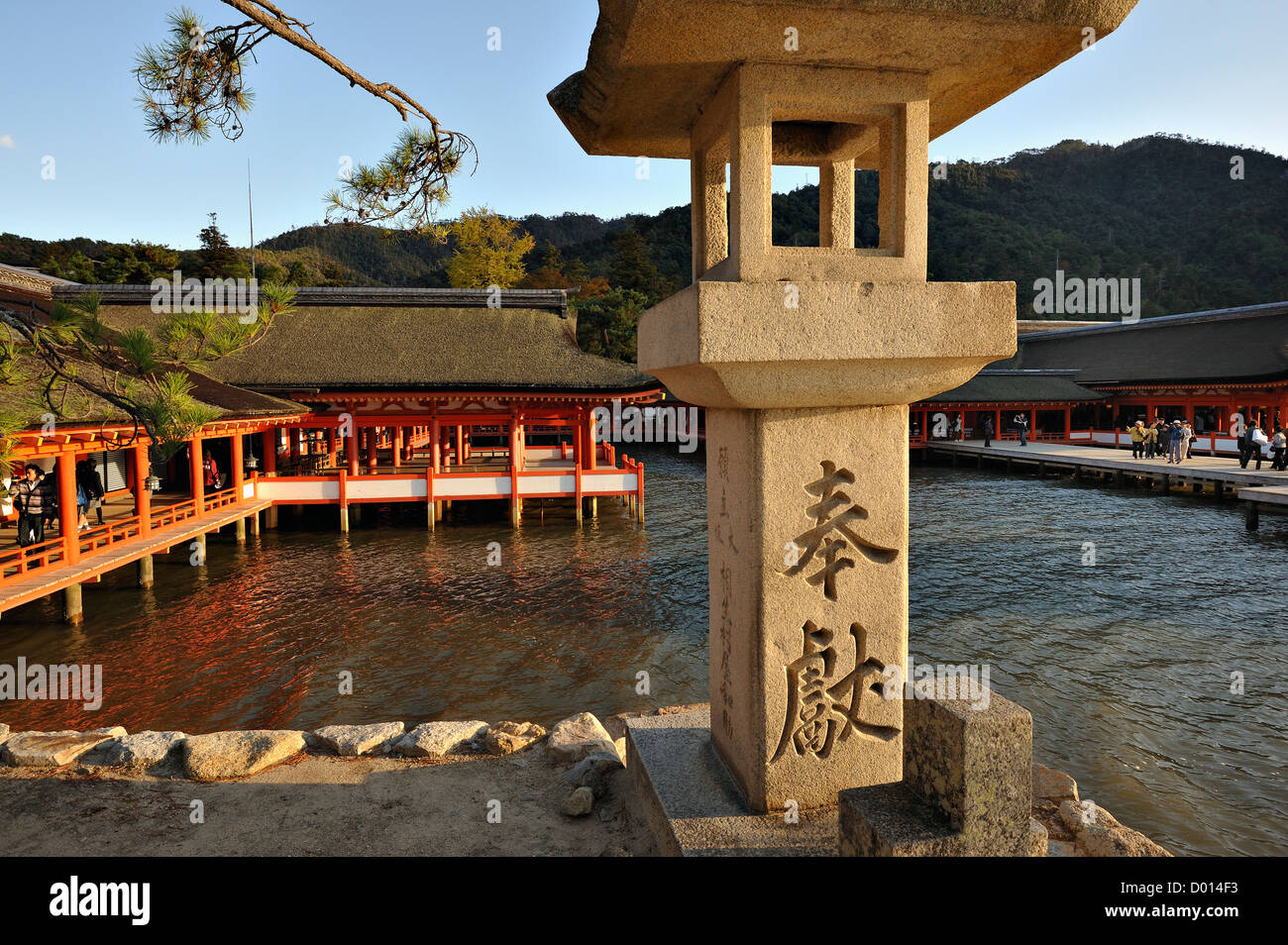 Stone lantern and red pavillion at Itsukushima Shrine on the island of Miyajima, Japan Stock Photo