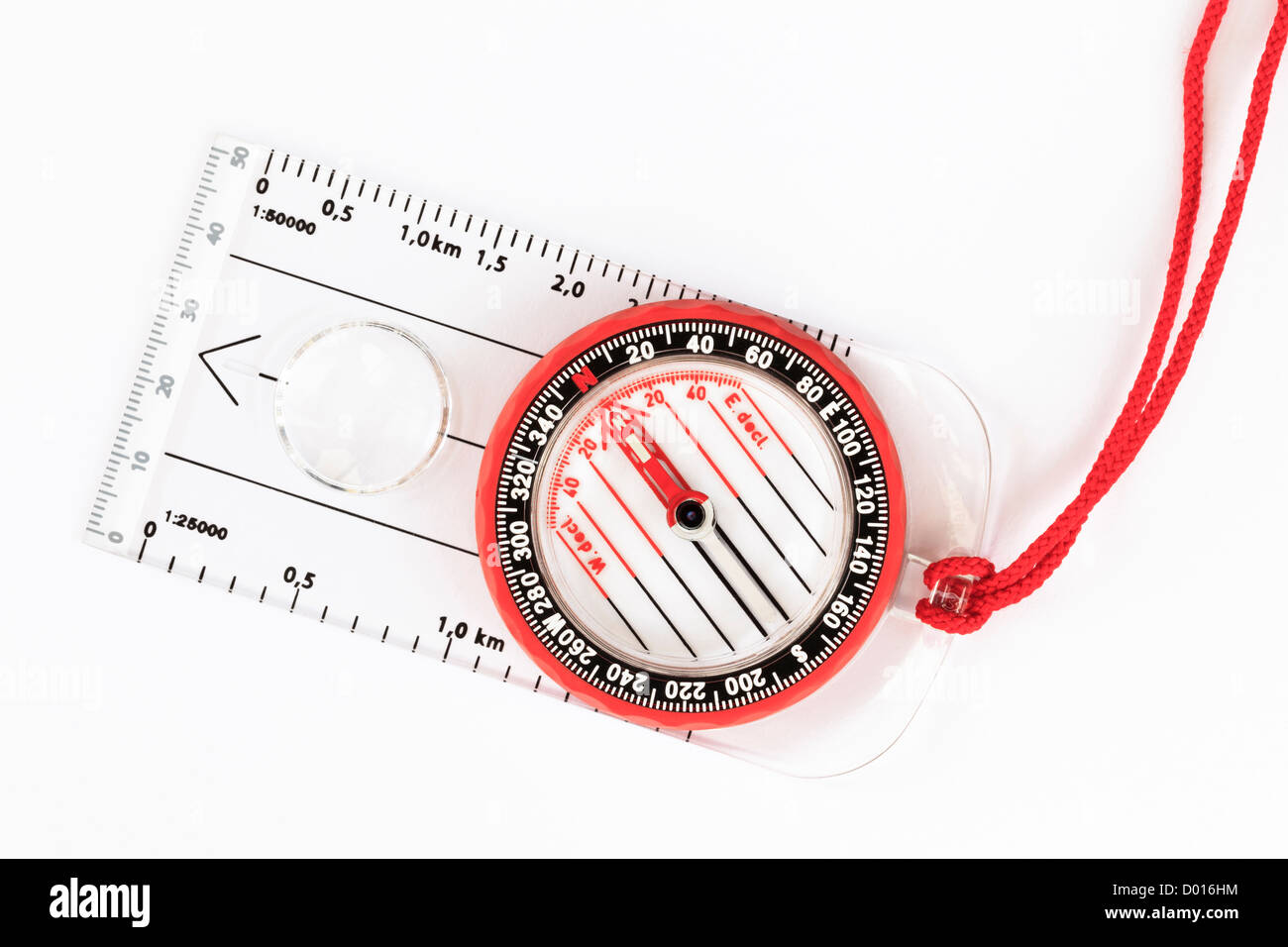 Close-up of a modern orienteering base plate hiking compass pointing north direction for navigation with red lanyard on a white background from above Stock Photo