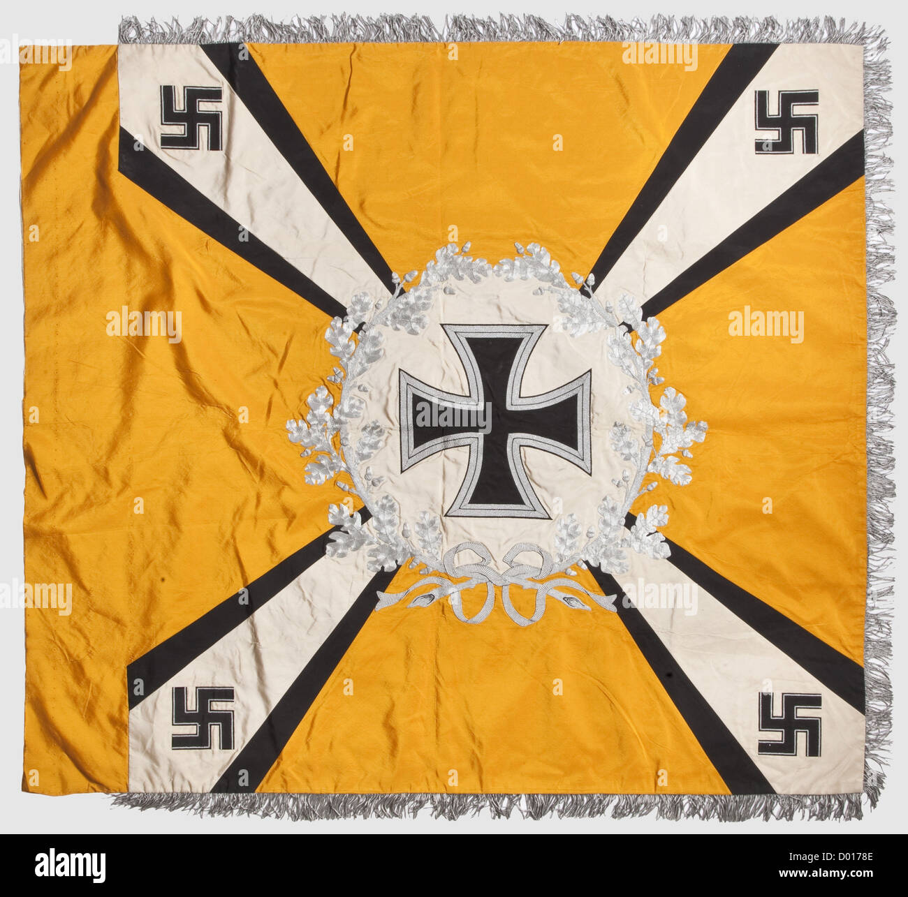 A flag for flying or parachute troops,of yellow silk with lavish aluminium embroidery and silver fringe on three sides.Both sides with a white disc surrounded by an oak leaf wreath over four diagonal white beams,widening towards the corners and framed by black borders,each of silk.At the beam corners horizontal black silk swastikas with silver borders.At the centre of the disc on the right side,extending over the wreath,a Luftwaffe eagle embroidered in relief with different threads,on the left side is an Iron Cross.Embroidered maker's designation 'O.,Additional-Rights-Clearences-Not Available Stock Photo
