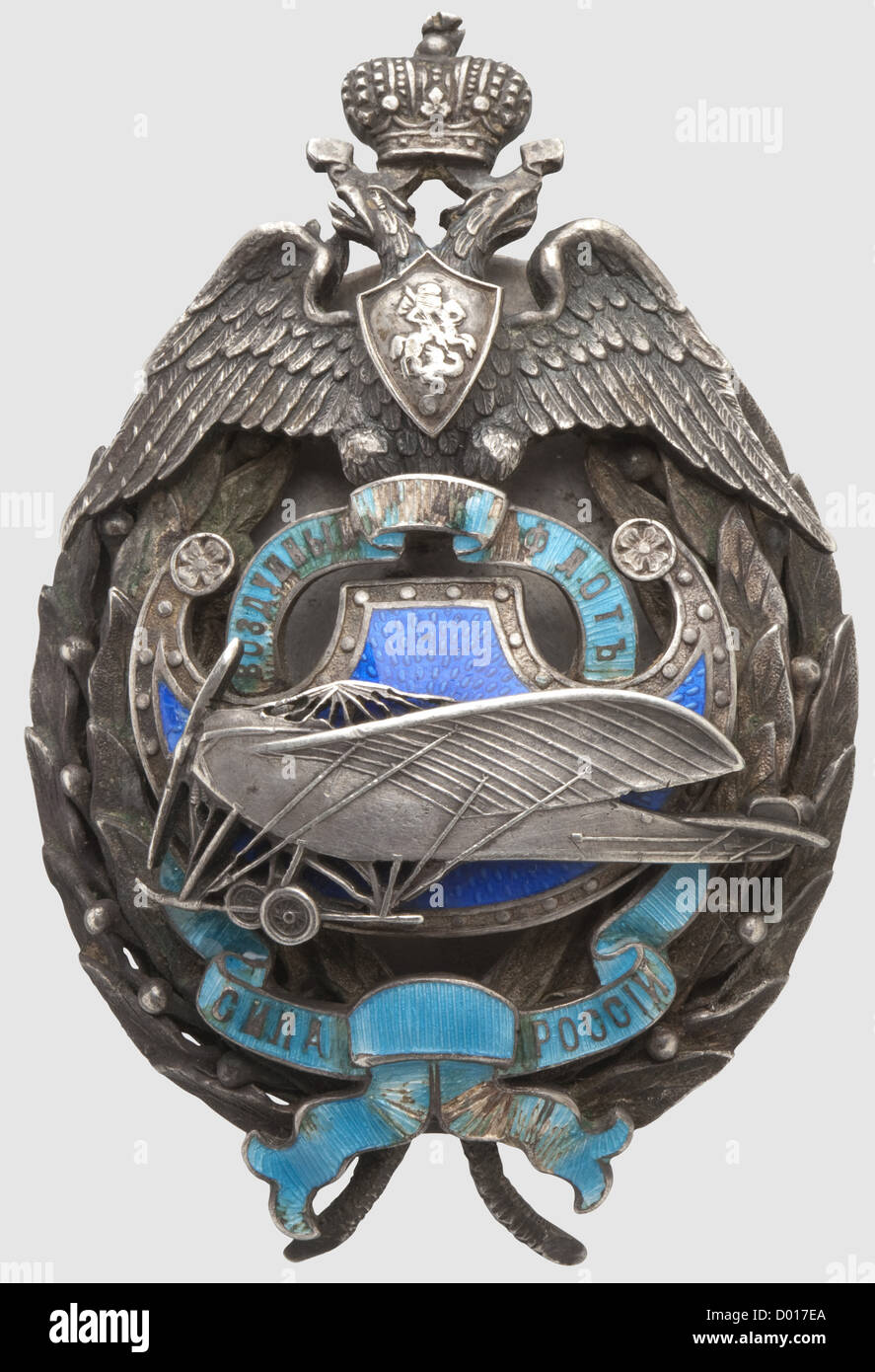 A Standard Flyer's Badge,Russia circa 1914. Silver,fashioned in multiple sections,enamelled areas. Interlaced bandeau(chipped)with Cyrillic inscription(tr)'Russia's Strength - Aviation'. Reverse Cyrillic master's mark 'VA',kokoschnik punch as well as fineness punch for '84' zolotniki. Pressure plate with maker's mark 'Eduard',master's mark 'VA' and kokoschnik head punch. Dimensions 70 x 46 mm,weight 59 g. Fine quality,historic,historical,1910s,20th century,medal,decoration,medals,decorations,badge of honour,badge of honor,badges of honour,,Additional-Rights-Clearences-Not Available Stock Photo