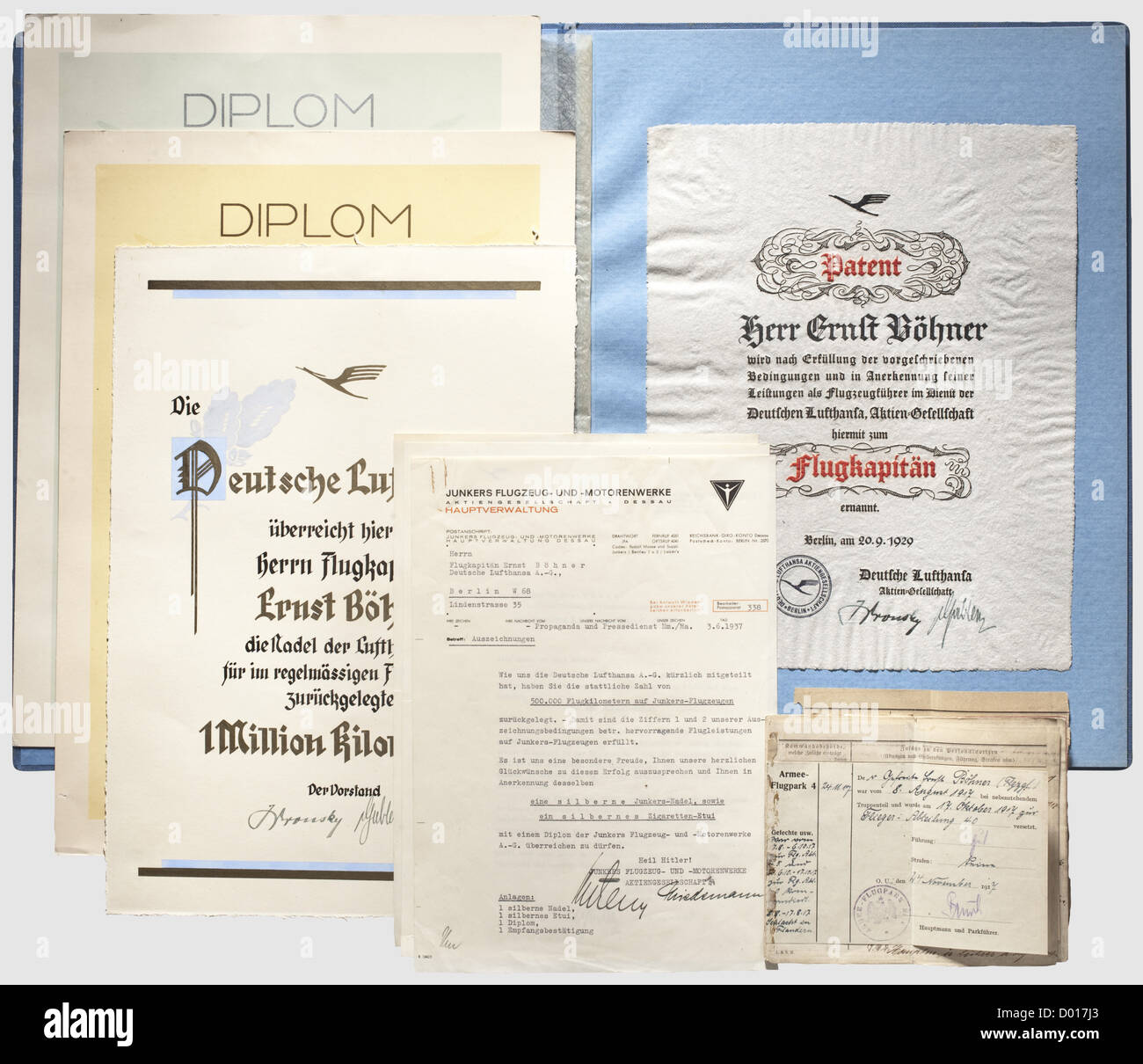 Documents of a Flight Captain in German Lufthansa,Patent to Flugkapitän dated 20 September 1929 and document for Lufthansa badge for over 1 million flight service kilometres dated 9 April 1935,each on hand-made paper with text rendered in black and red.Included is a blue award folder with a gold-stamped crane,a decorative document for Lufthansa stickpin for over 1 million kilometres dated 10 April 1935 and two diplomas from Junkers factory for more than 500,000 and 750,000 kilometres covered in Junkers aircraft,with best wishes and transmit,Additional-Rights-Clearences-Not Available Stock Photo