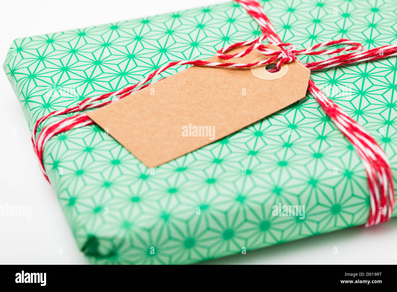 Closeup of simple gift package with green wrapping and plain cardboard