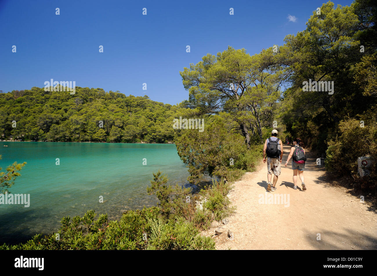croatia, dalmatia, mljet island, malo jezero lake, people walking along coastal path Stock Photo
