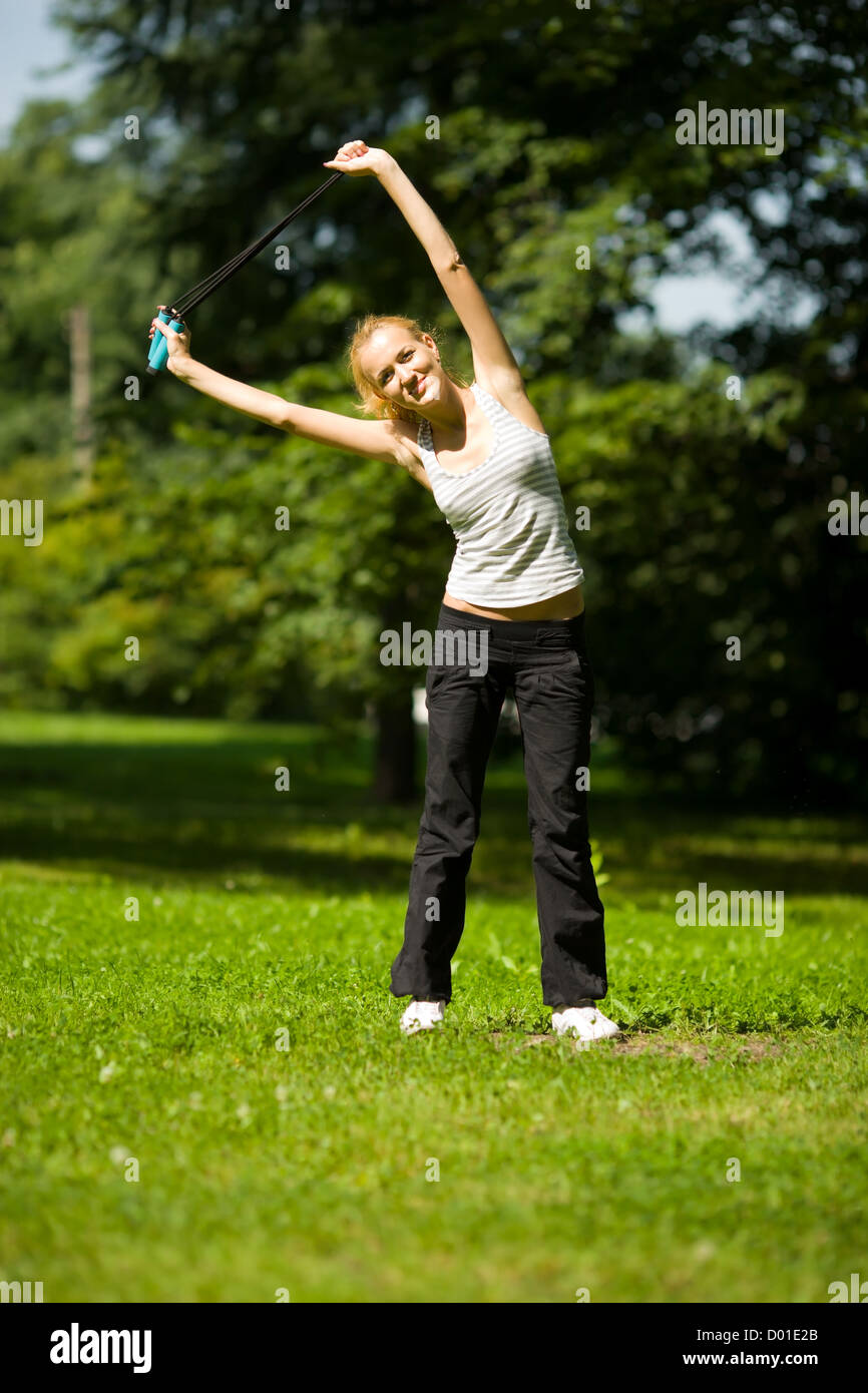 stretching Young woman exercising in summer park Stock Photo - Alamy