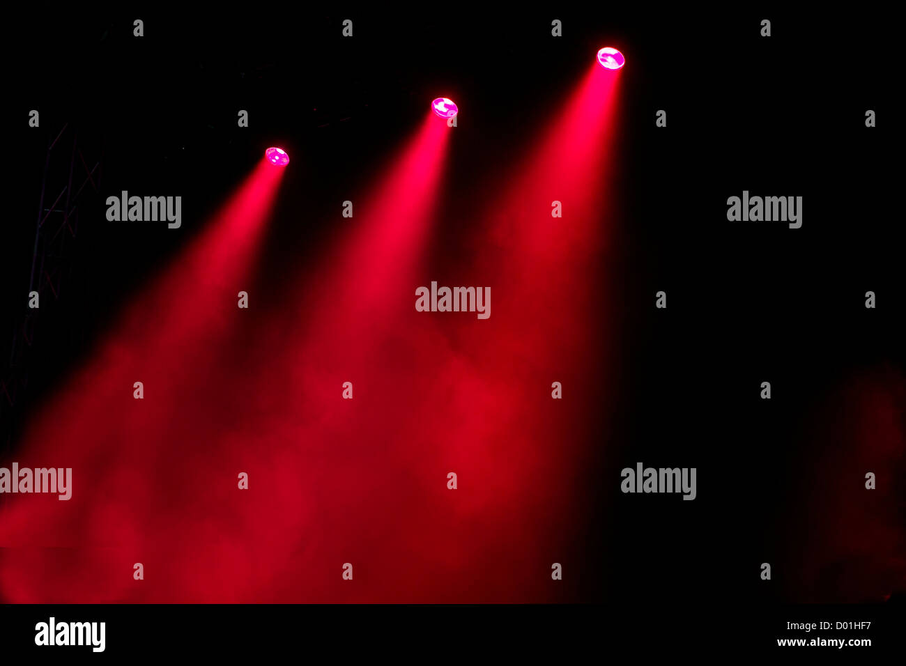 Shafts of coloured colored lighting shine through  atmospheric smoke in a dramatic way to light an empty stage Stock Photo