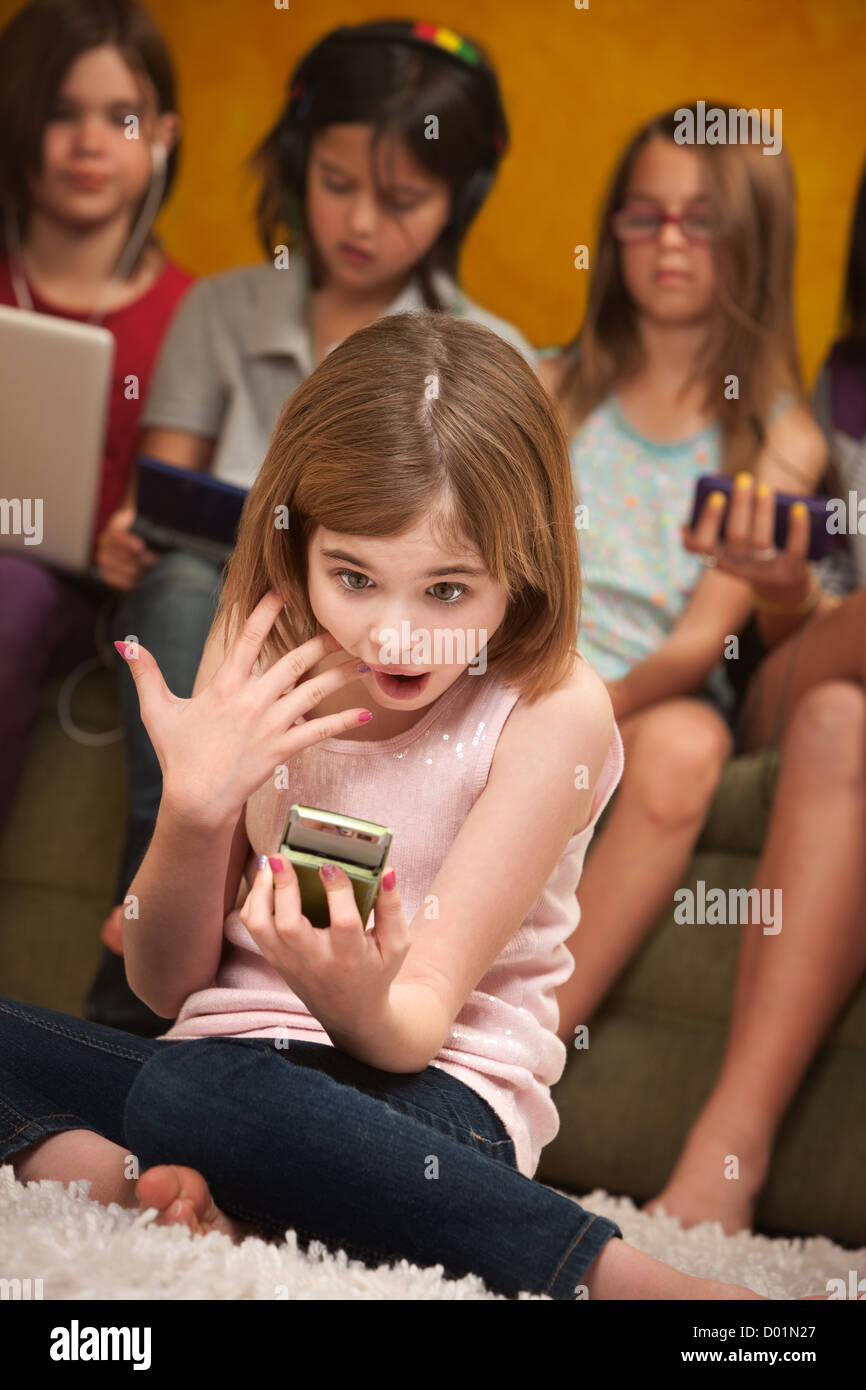 Surprised little Caucasian girl with a handheld device Stock Photo