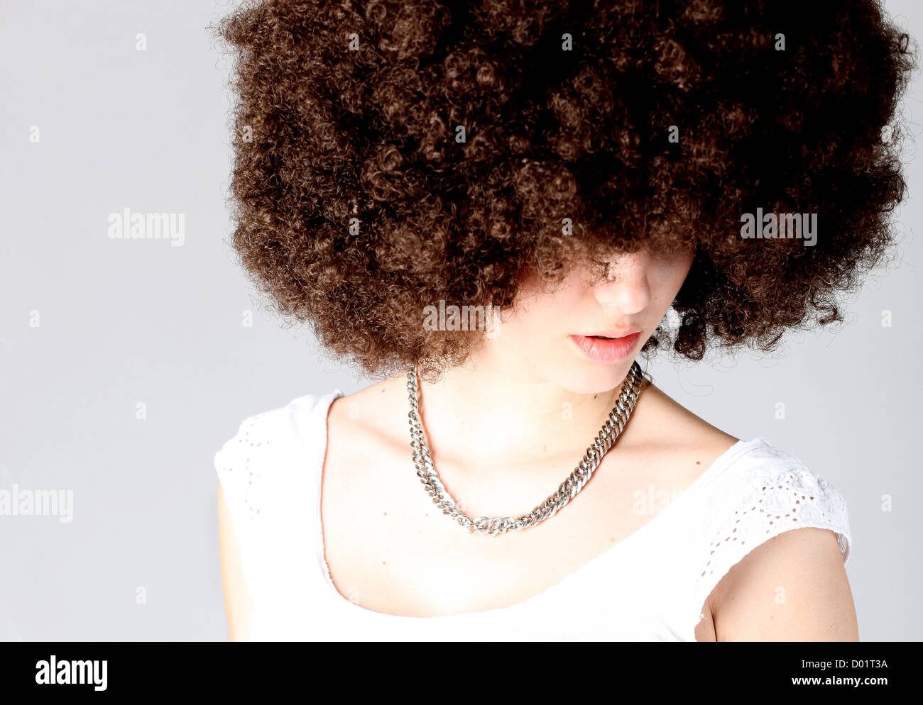 Young woman wearing a wig against gray background Stock Photo