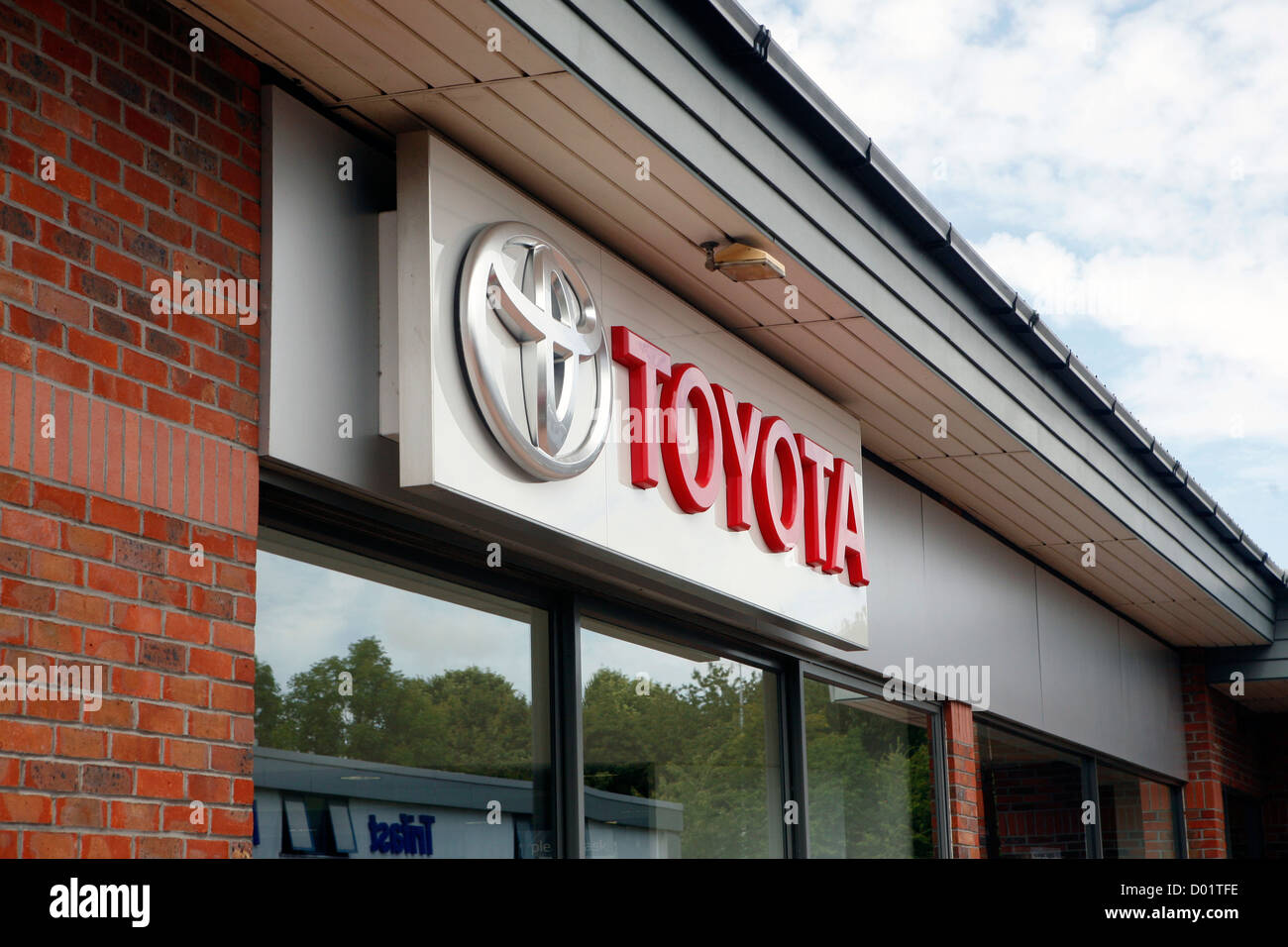 A big Toyota logo on the side of a Toyota car dealership. Stock Photo