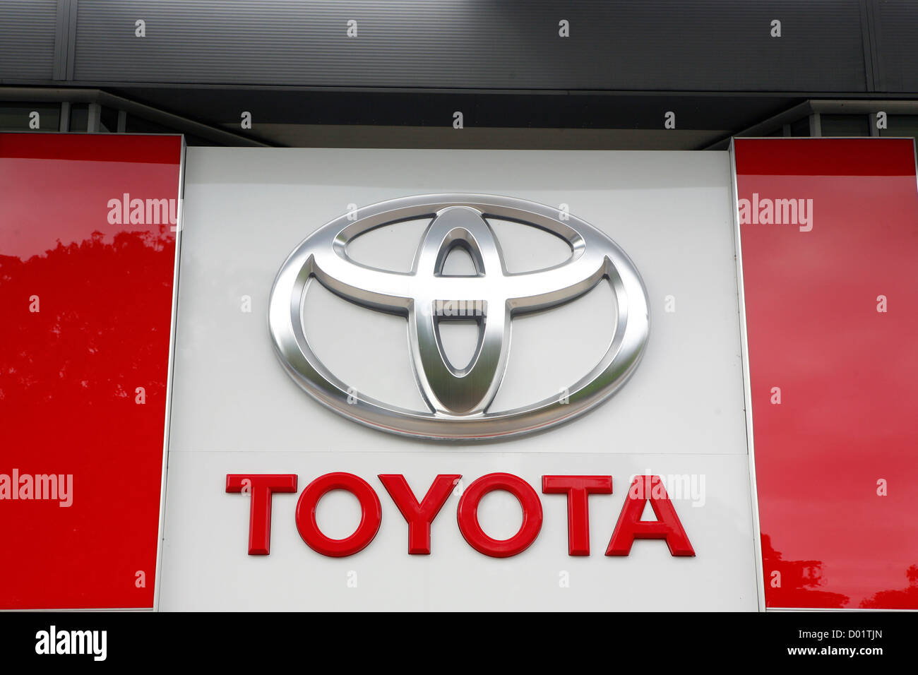 A big Toyota logo on the side of a Toyota car dealership. Stock Photo