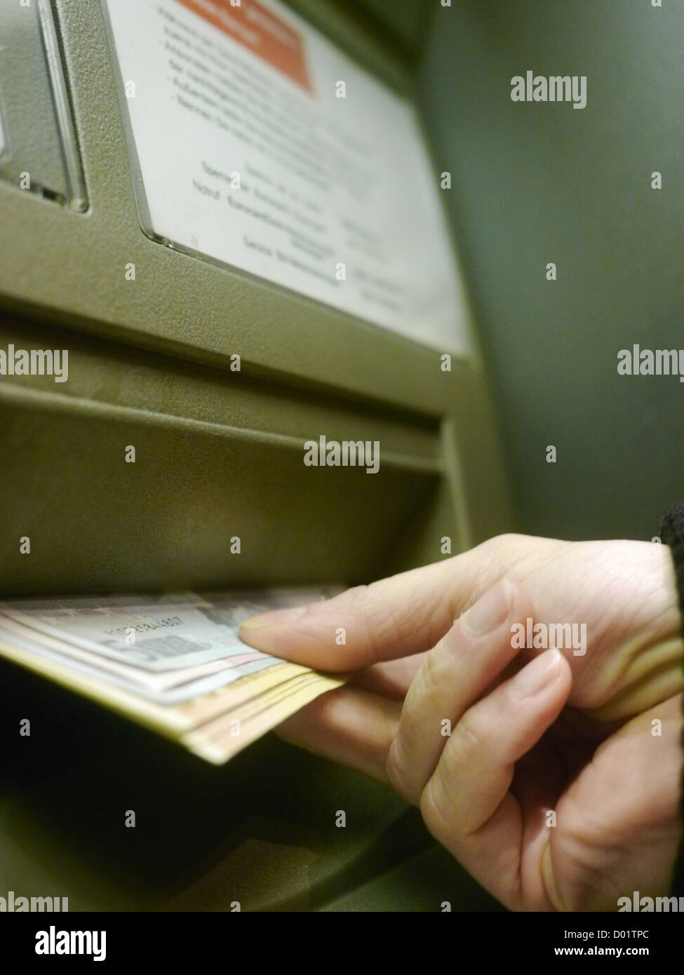 Finger using automatic teller keypad to enter pin number Stock Photo