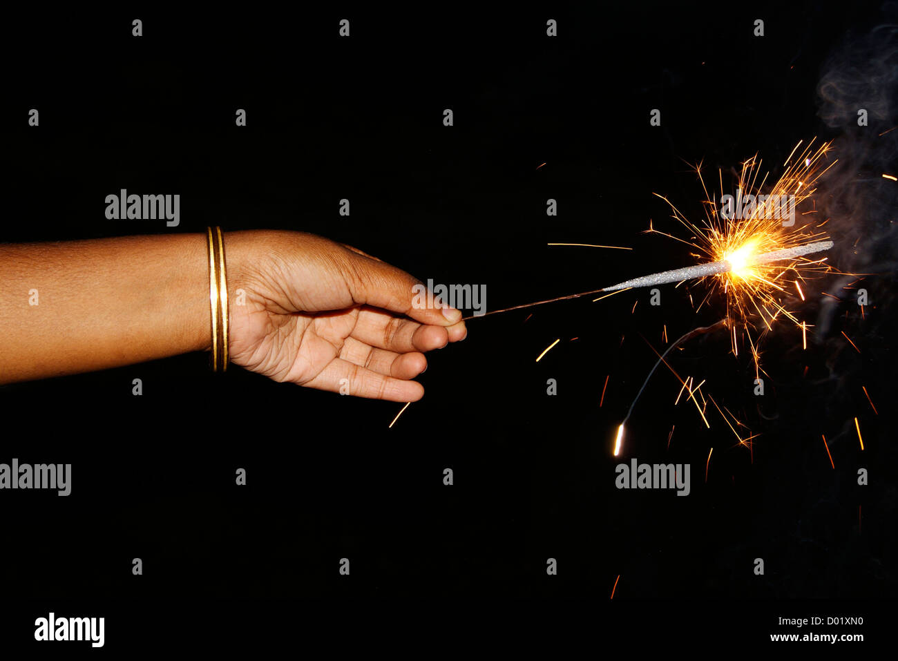 Girl Holding fireworks display Sparker on hands during the occasion of Diwali or Deepavali Festival celebration in India Stock Photo