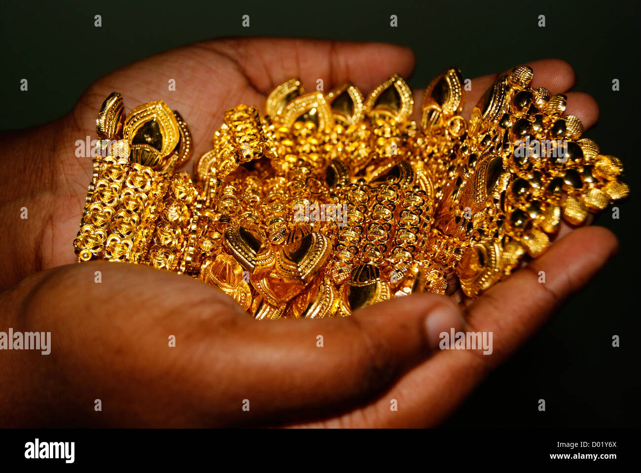 Young Girl Holding Gold Necklace Jewellery Ornaments on Hands Closeup Black Cutout view Stock Photo