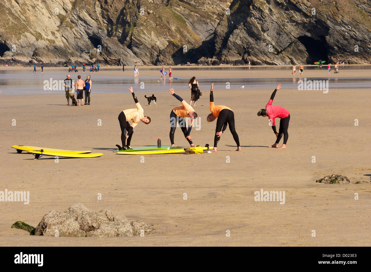 Surfers doing their presurf exercises with their instructor at Newquay, Cornwall, South West