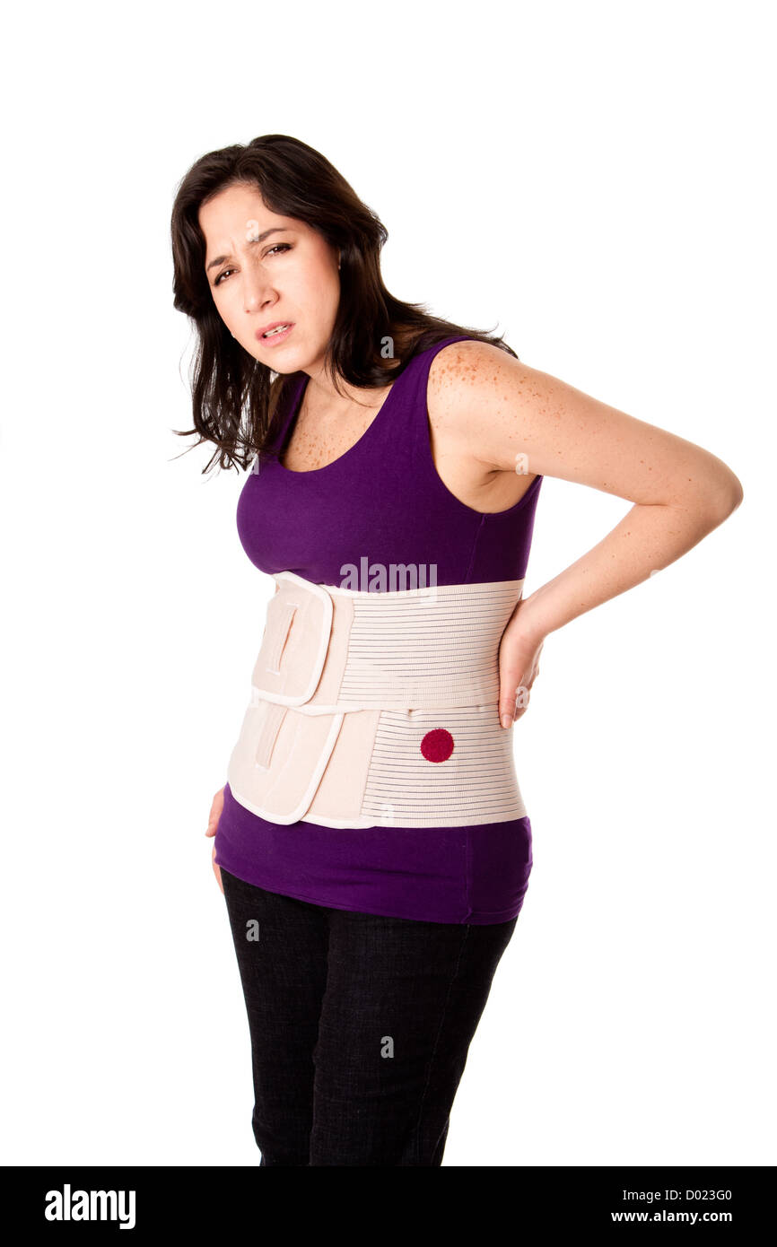 Woman in pain from back injury wearing an orthopedic body brace corset