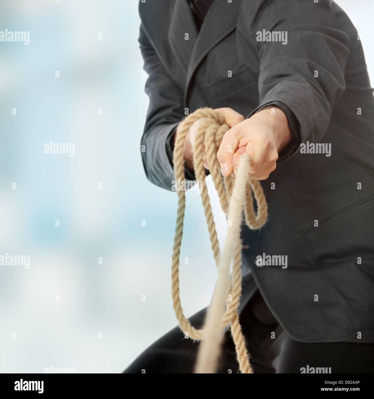 Businessman pulling on a rope Stock Photo - Alamy