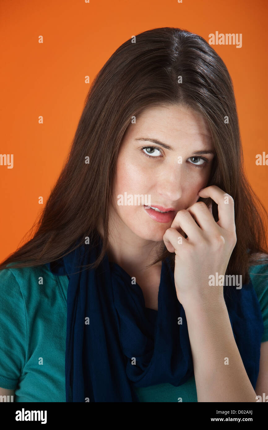 Young cute girl looking shy with her fingers on her face Stock Photo ...