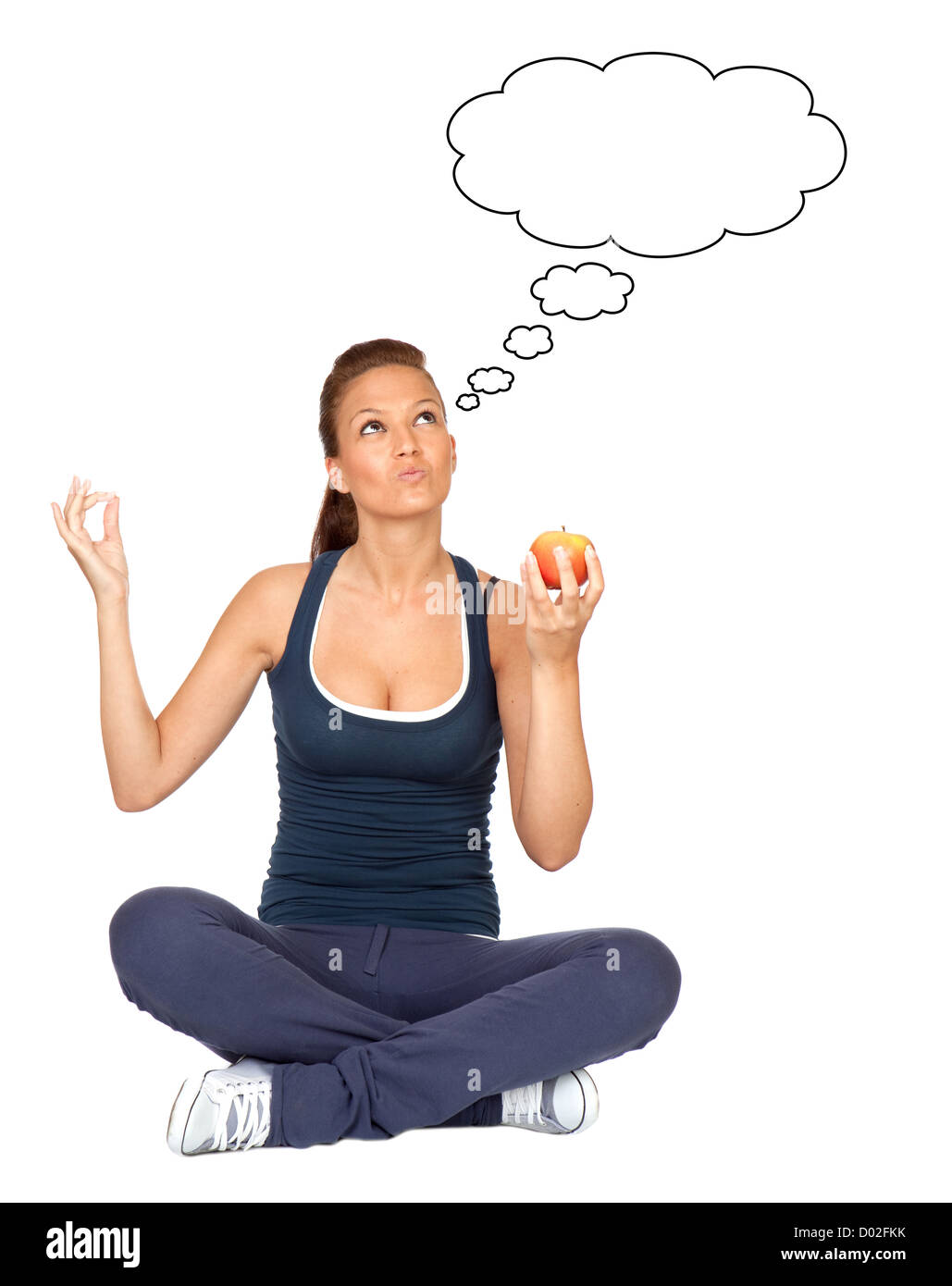 Gymnastics girl thinking with an apple sitting with cross-legs on white background Stock Photo