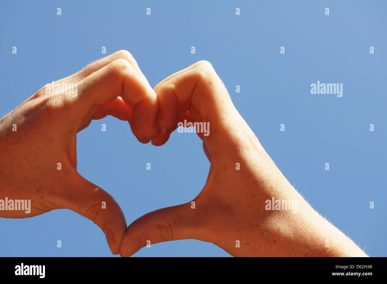 love concept with hand heart and blue sky copyspace Stock Photo - Alamy