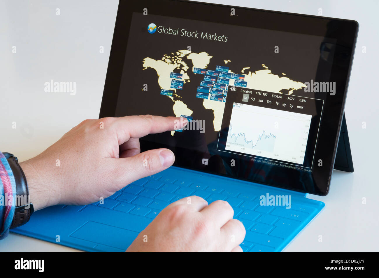 Man checking financial performance of stock markets on Microsoft Surface rt tablet computer Stock Photo