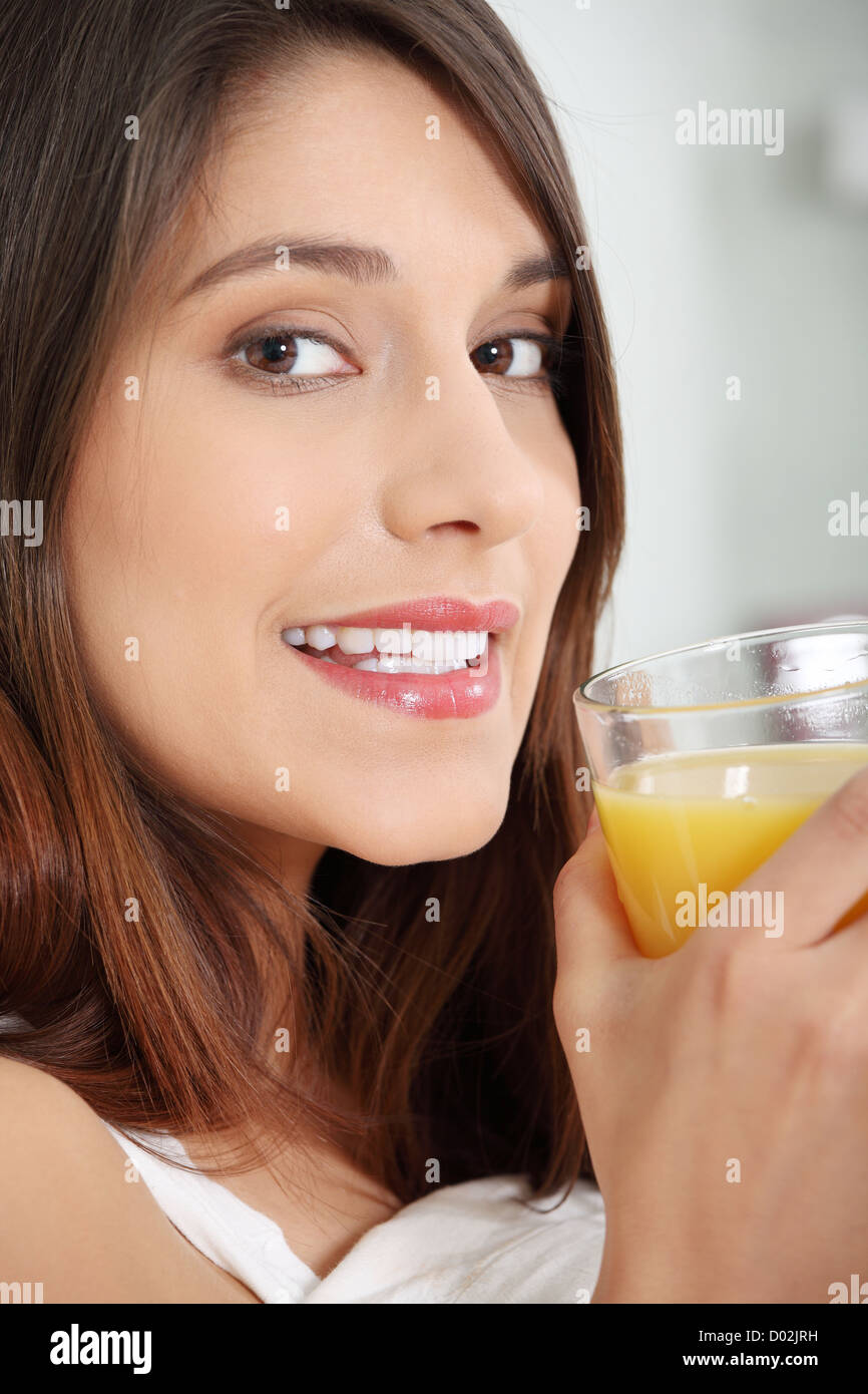 Woman in bed drinking orange juice Stock Photo Alamy