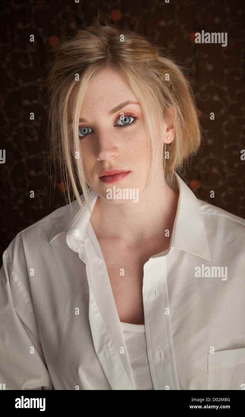 Serious young blonde girl in a white shirt Stock Photo - Alamy