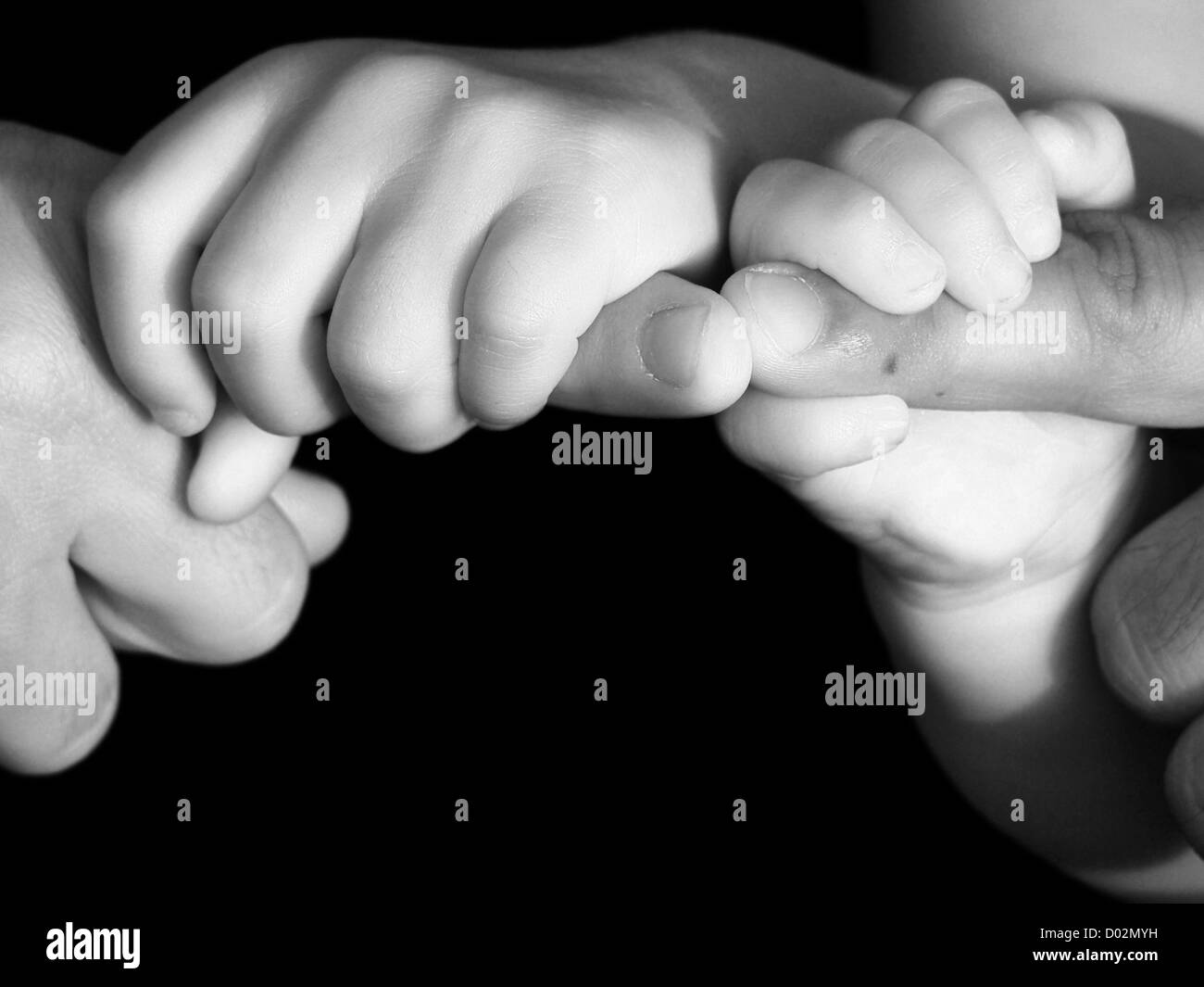 Family Hands Father and child's interlocked hands in black and white Stock Photo