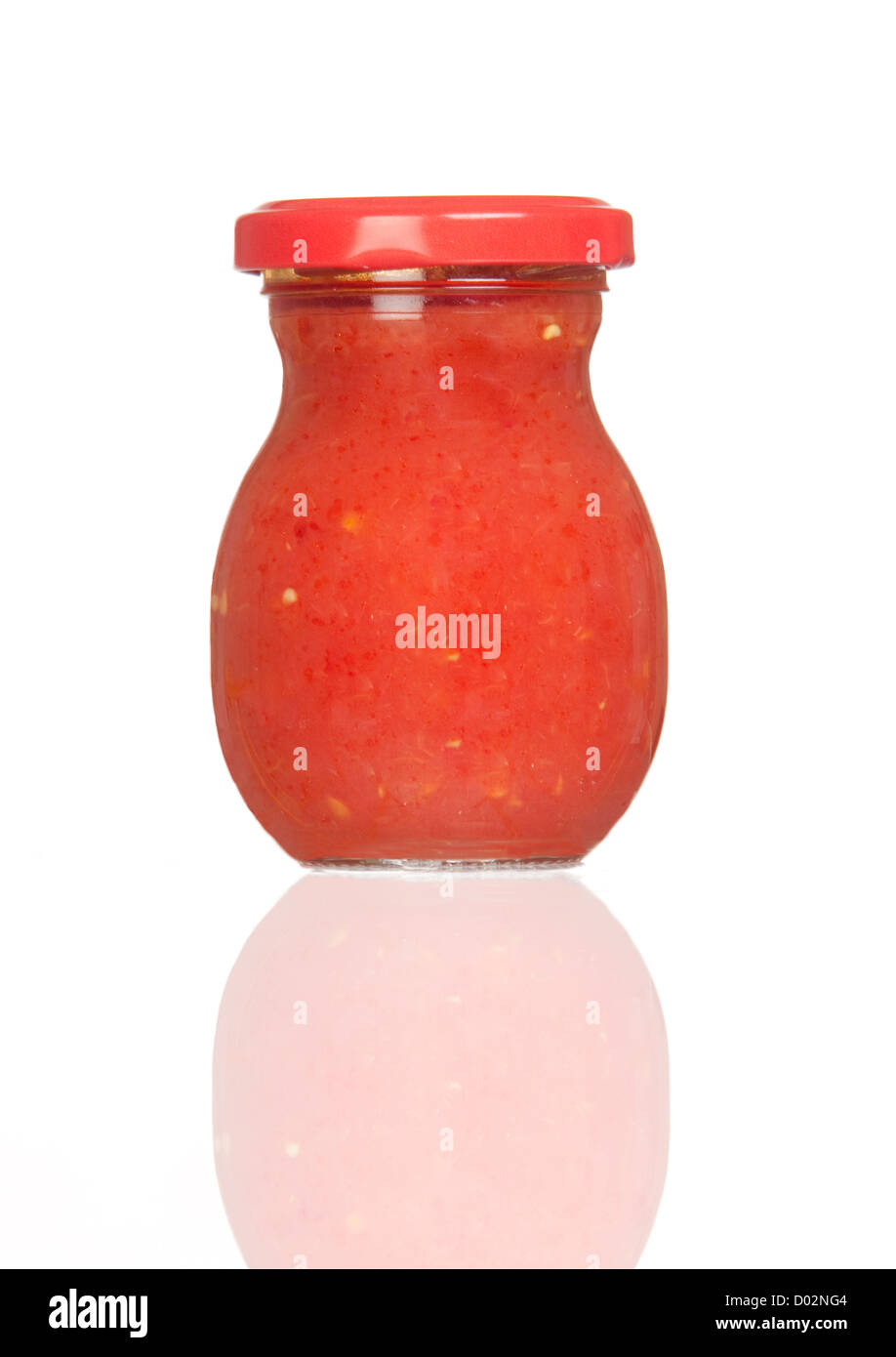 Glass jar of tomato paste with reflection isolated on white background
