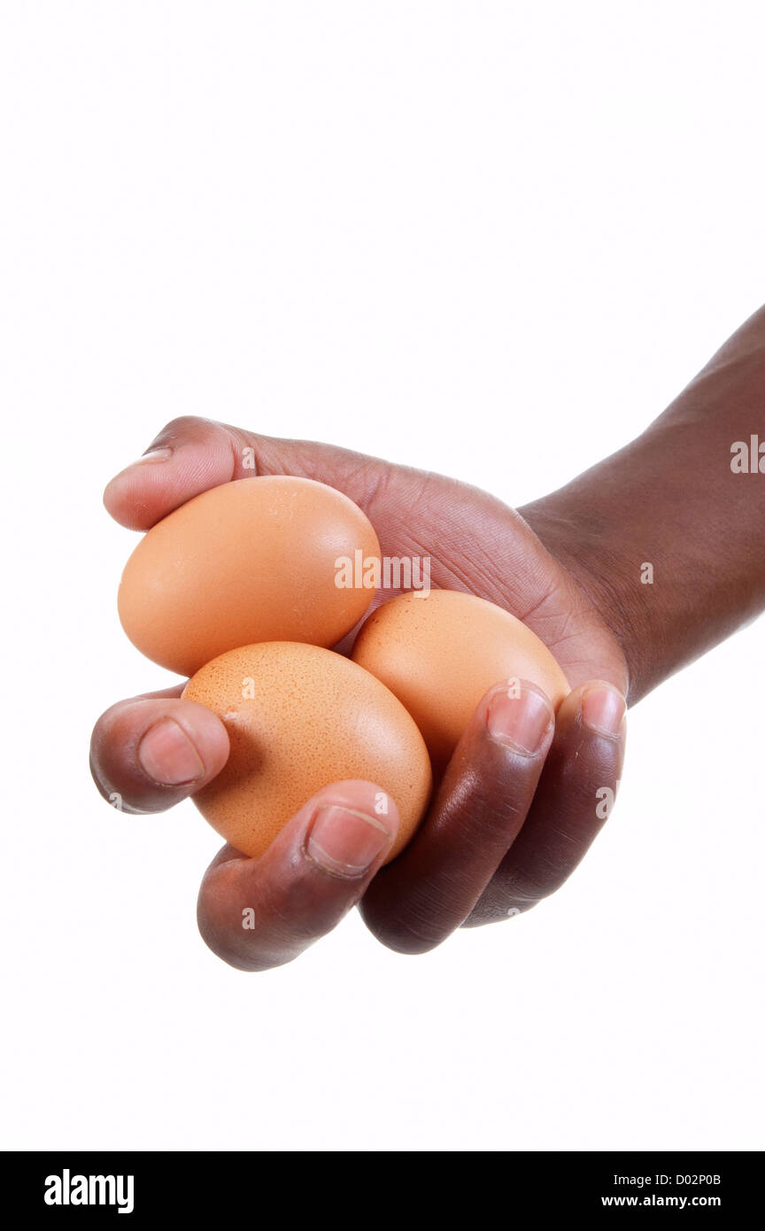 An open hand holding three chicken's eggs Stock Photo