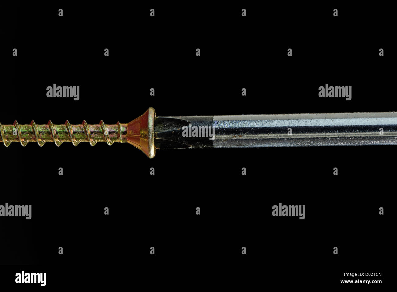 Close-up of a screwdriver driving a brass screw - 36MP image Stock Photo