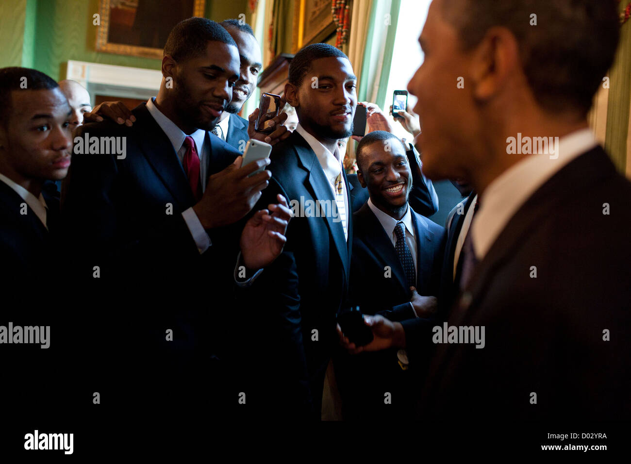 US President Barack Obama greets members of the University of Connecticut men's basketball team May 16, 2011 in the Green Room of the White House following an event celebrating the team's 2010 NCAA basketball championship. Stock Photo