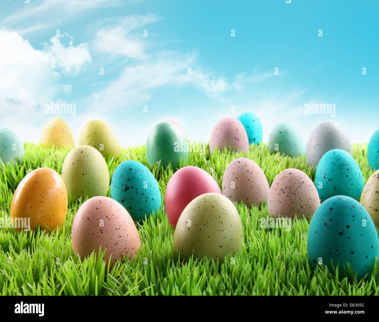 Colorful Easter eggs in a field of grass with blue sky Stock Photo - Alamy