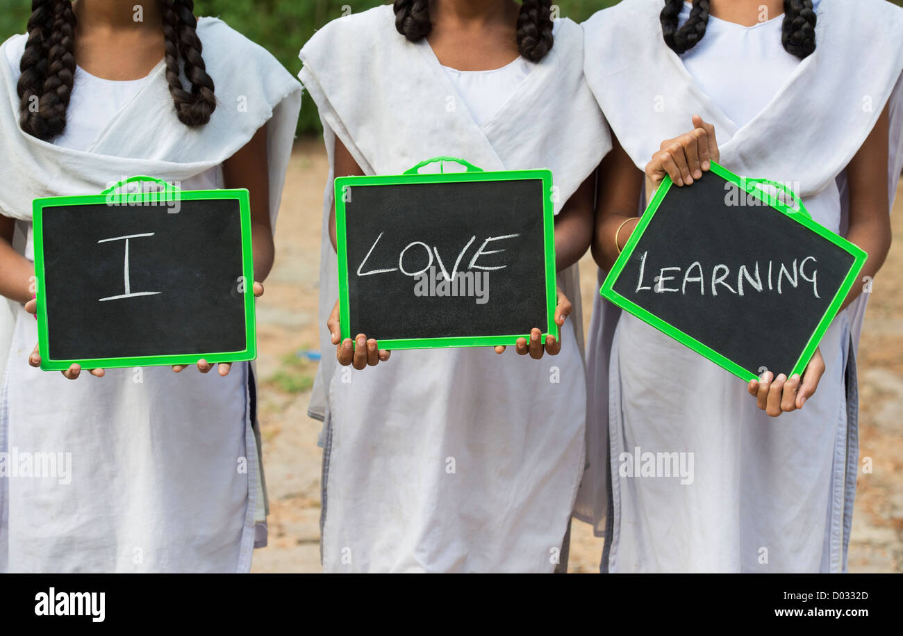Three Indian village school girls with I LOVE LEARNING written on a chalkboard. Andhra Pradesh, India Stock Photo