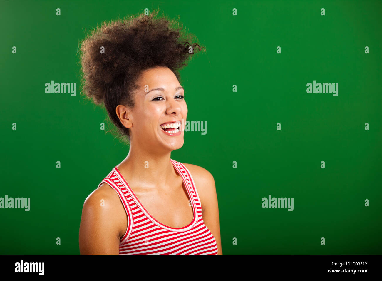 Beautiful African woman laughing over a green background Stock Photo ...