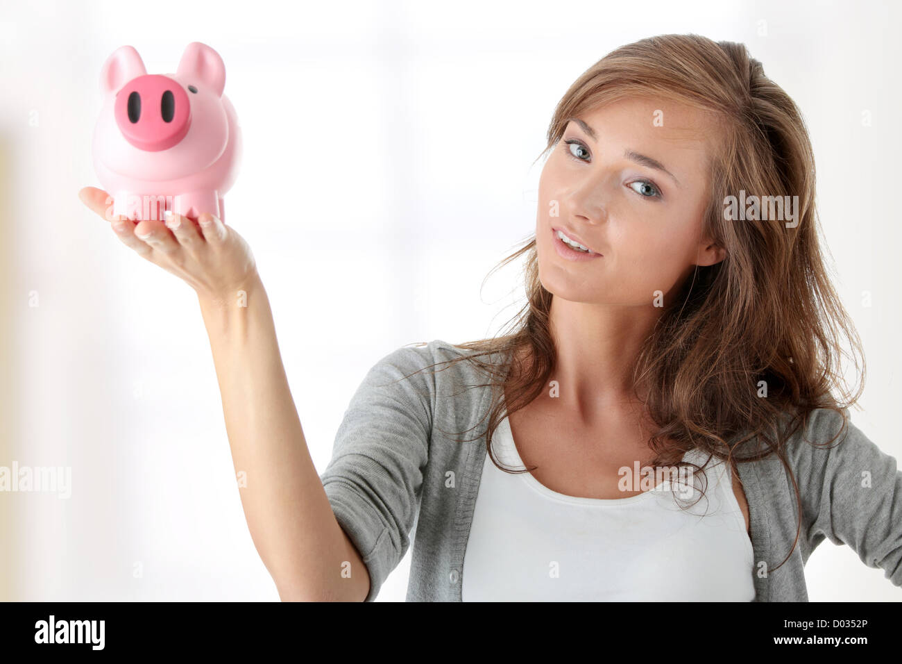 Young beautiful woman standing with piggy bank Stock Photo - Alamy