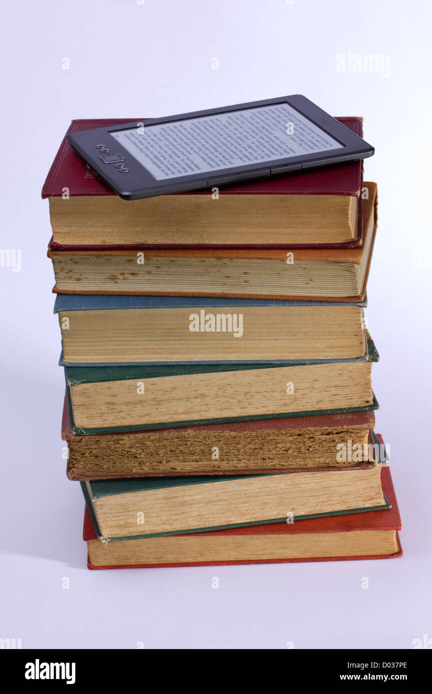 Pile of old books with Kindle eBook reader Stock Photo Alamy