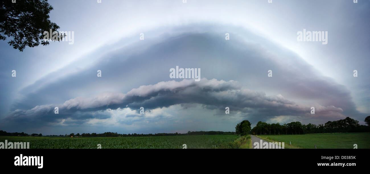A role cloud is rolling in front of a depression in the Netherlands at the end of a warm day bringing thunderstorm Stock Photo